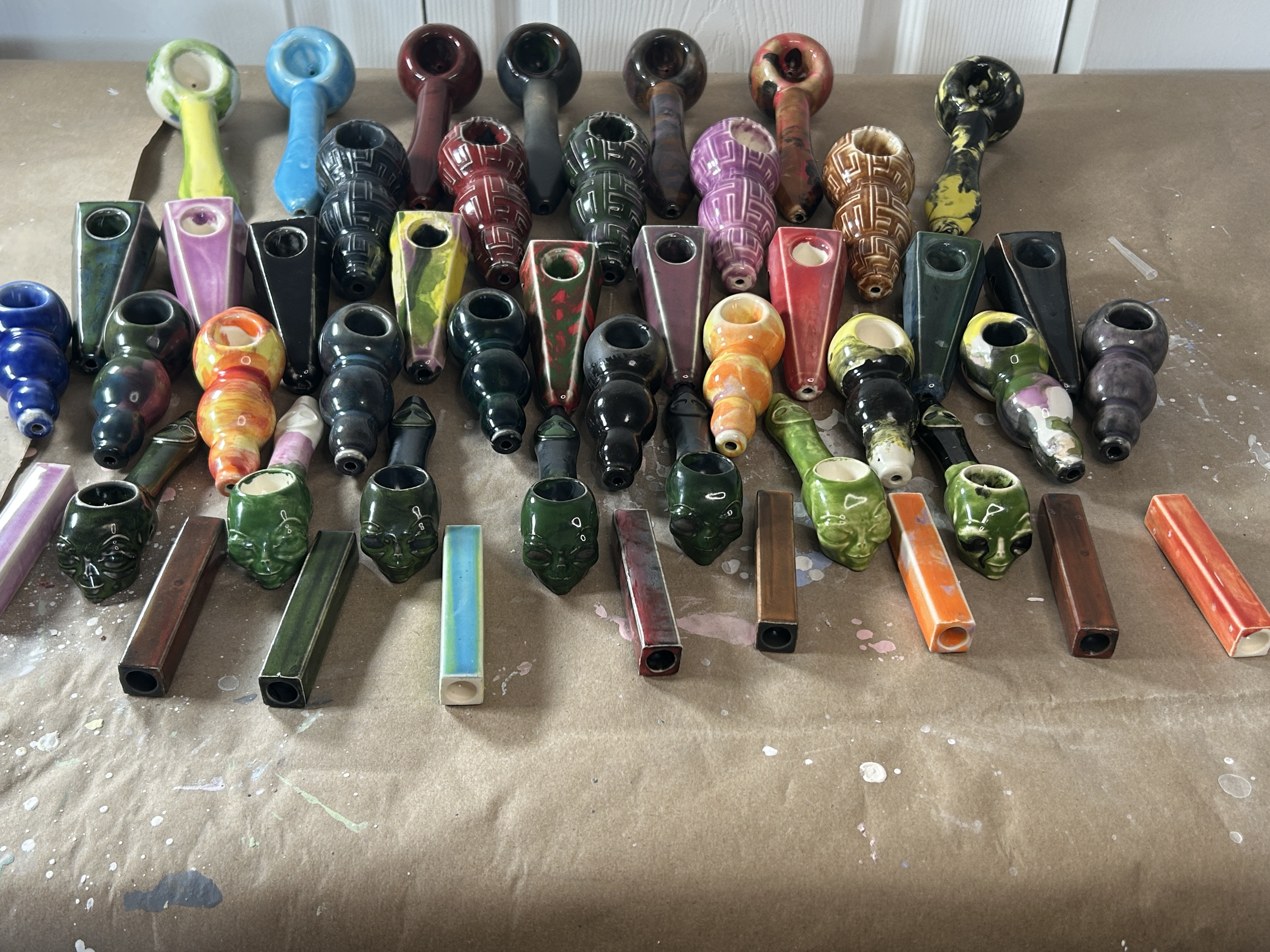 Handmade ceramic pipes arranged in a warm ceramic studio setting